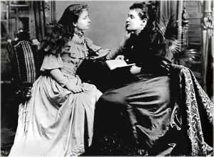 Svartvit bild på en ung Helen Keller som avläser sin lärare Anne Sullivans läppar. Foto.