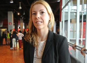 Saskia Damen med långt ljust hår står i en foajé.