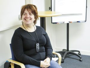 Amanda Lindberg i svart tröja sitter på en stol.