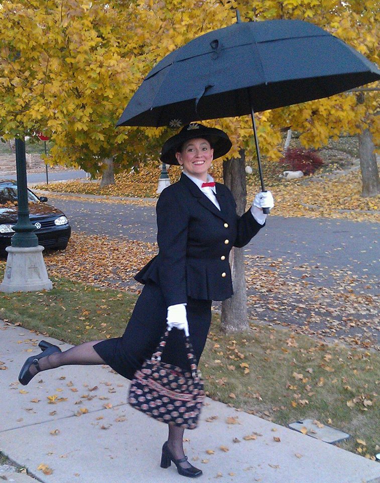 Laura har klätt sig som barnboksfigurejn Mary Poppins i svqrt dräkt och med paraplyet uppspänt.