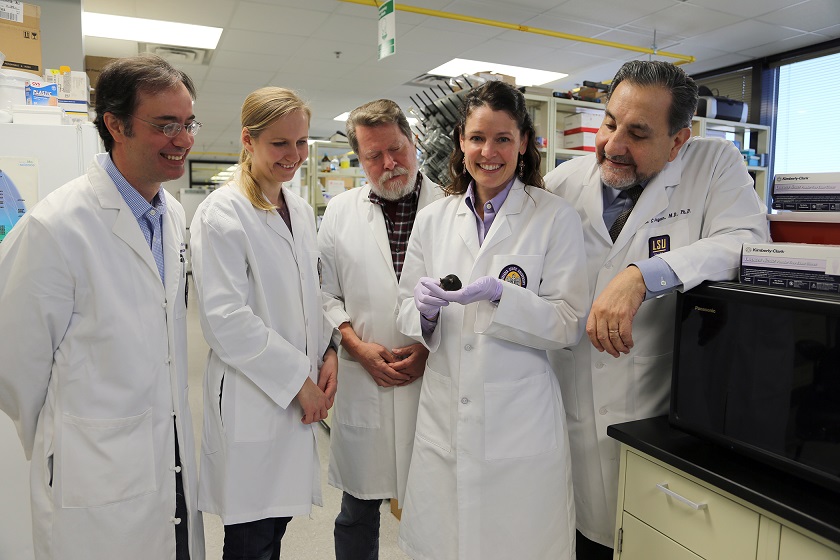 fem vitklädda forskare, i mitten Jennifer Lentz med usher-musen i handen.
