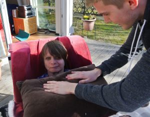 Anjas ansikte syns bakom den bruna kudden som John puffar på för att få kontakt.