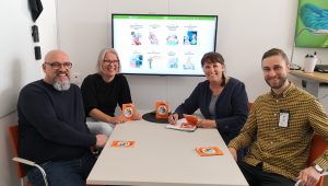 Miguel i glasögon och vittskägg, Petra i blond page och glasögon, Anette med brun hästsvans och Daniel med kort skägg och gulrutig skjorta. alla andra i svart eller grått.