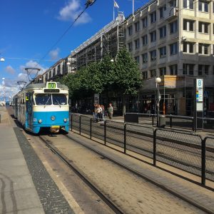 Gatubild med en blå och vit spårvagn. Foto.