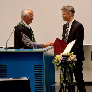 Daniel Prause tar i hand med rektor Vidar Leif Haanes. Foto.