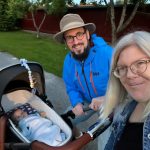 Helena och Fredrik står utomhus och tar en selfie tillsammans med Edgar i barnvagnen. De båda ler in i kameran. Foto.